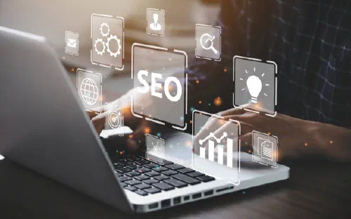 Person working on a laptop with floating SEO, analytics and web development icons